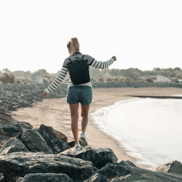 Femme marchant sur les rochers le long de la plage